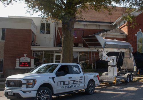Roofing company truck and equipment at a church under renovation.
