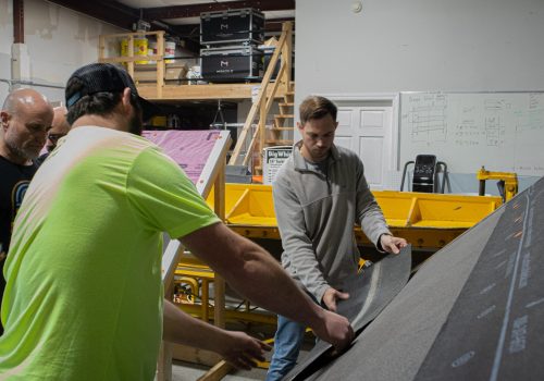 Roofing team working on a project in a construction workshop setting.