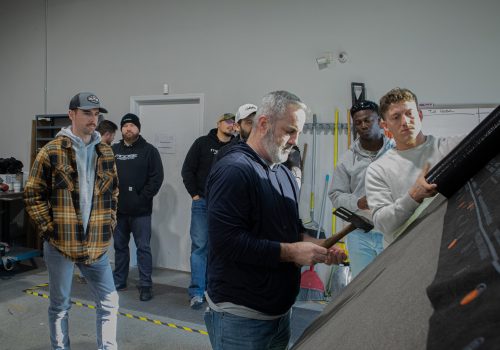 Roofing team collaborates in a workshop demonstrating installation techniques.